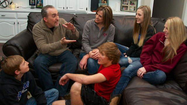 Dr. Mark Yarbrough seated on a couch with his wife and children