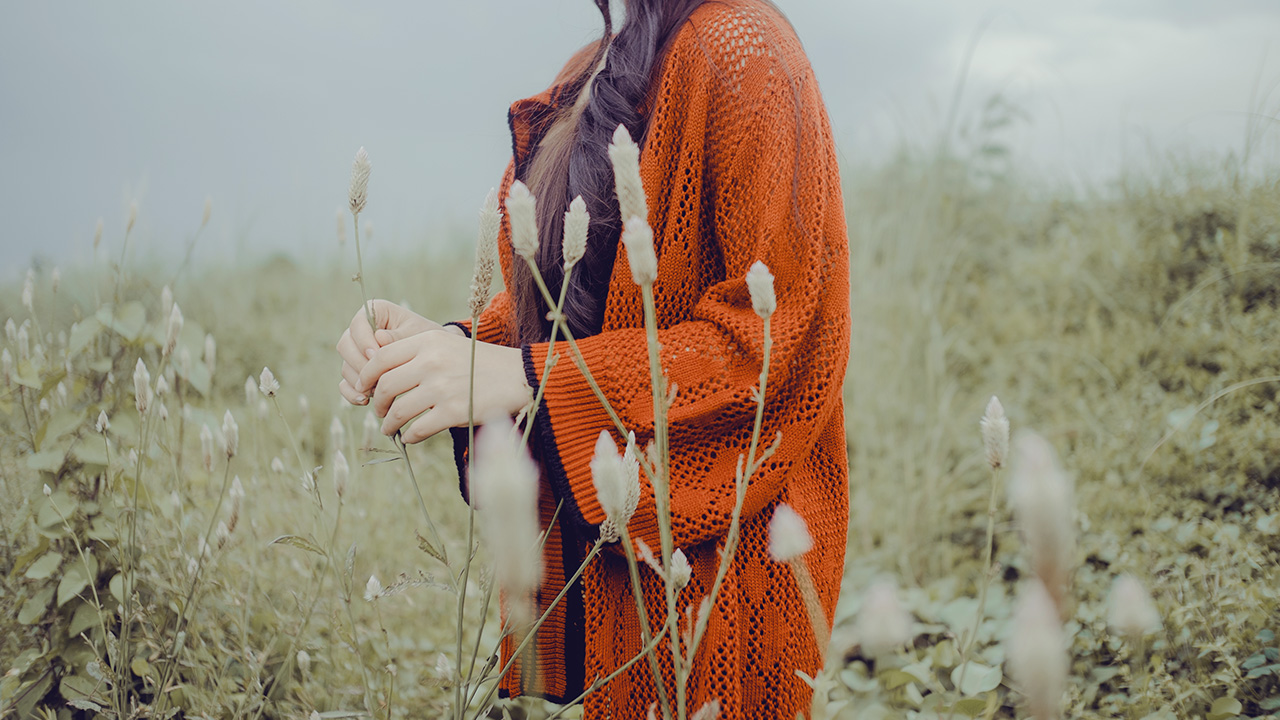 girl standing in tall grass