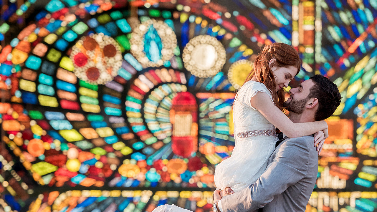 two people in front of a stained glass window