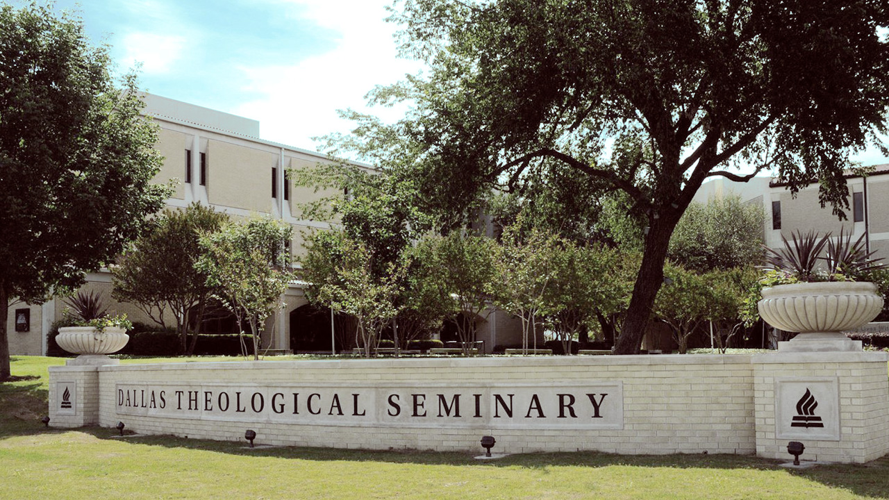 Exterior brick wall with planters engraved with Dallas Theological Seminary on North Lawn of campus